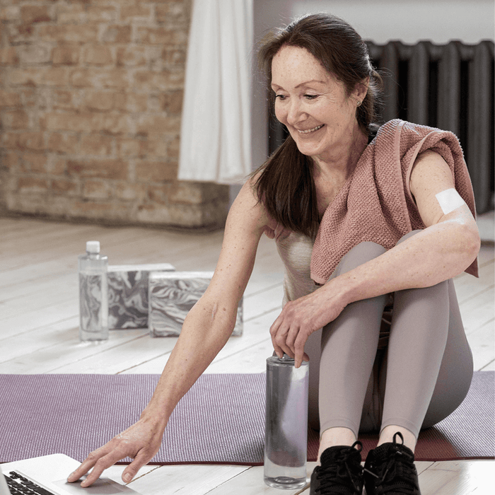 Woman With Joint Easing Patch on sitting on a Yoga Mat